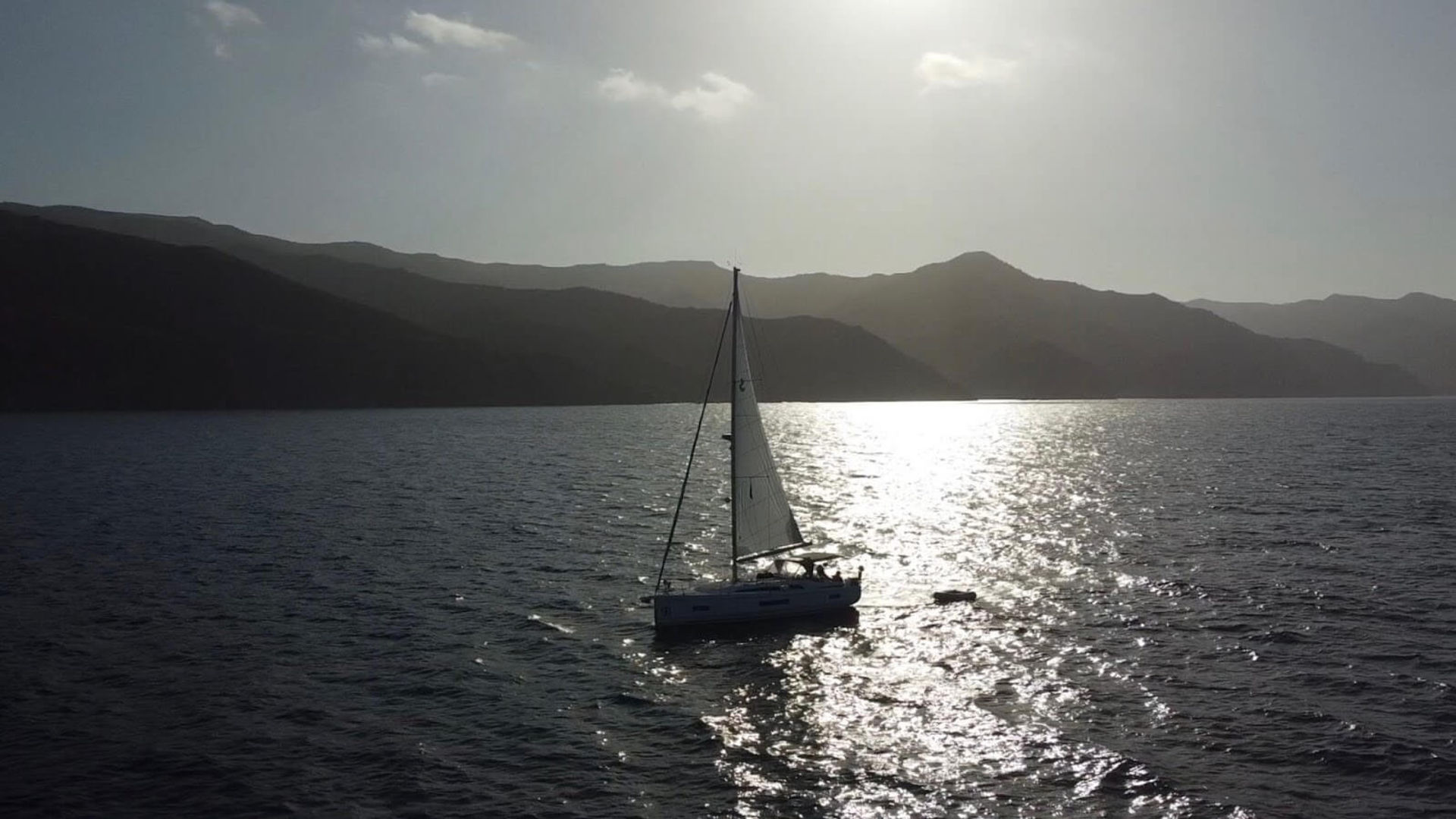 Young woman standing on deck looking at the mast during the Channel Islands flotilla.