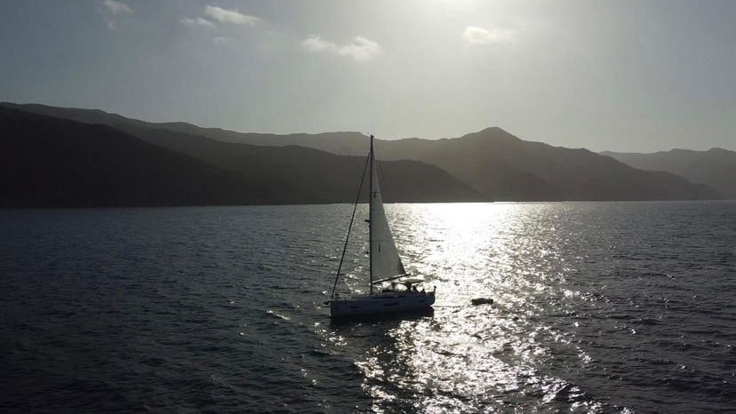 Young woman standing on deck looking at the mast during the Channel Islands flotilla.