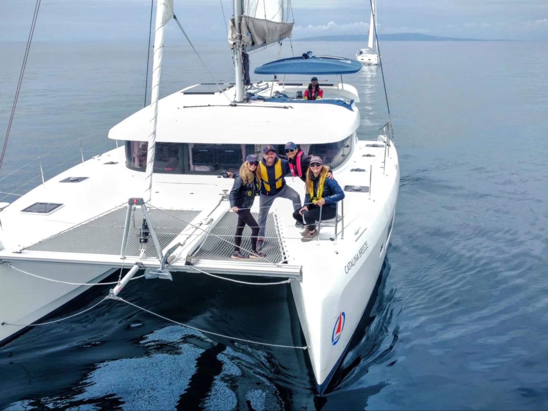 Catamaran Catalina Breeze with passengers on the bow trampoline at sea
