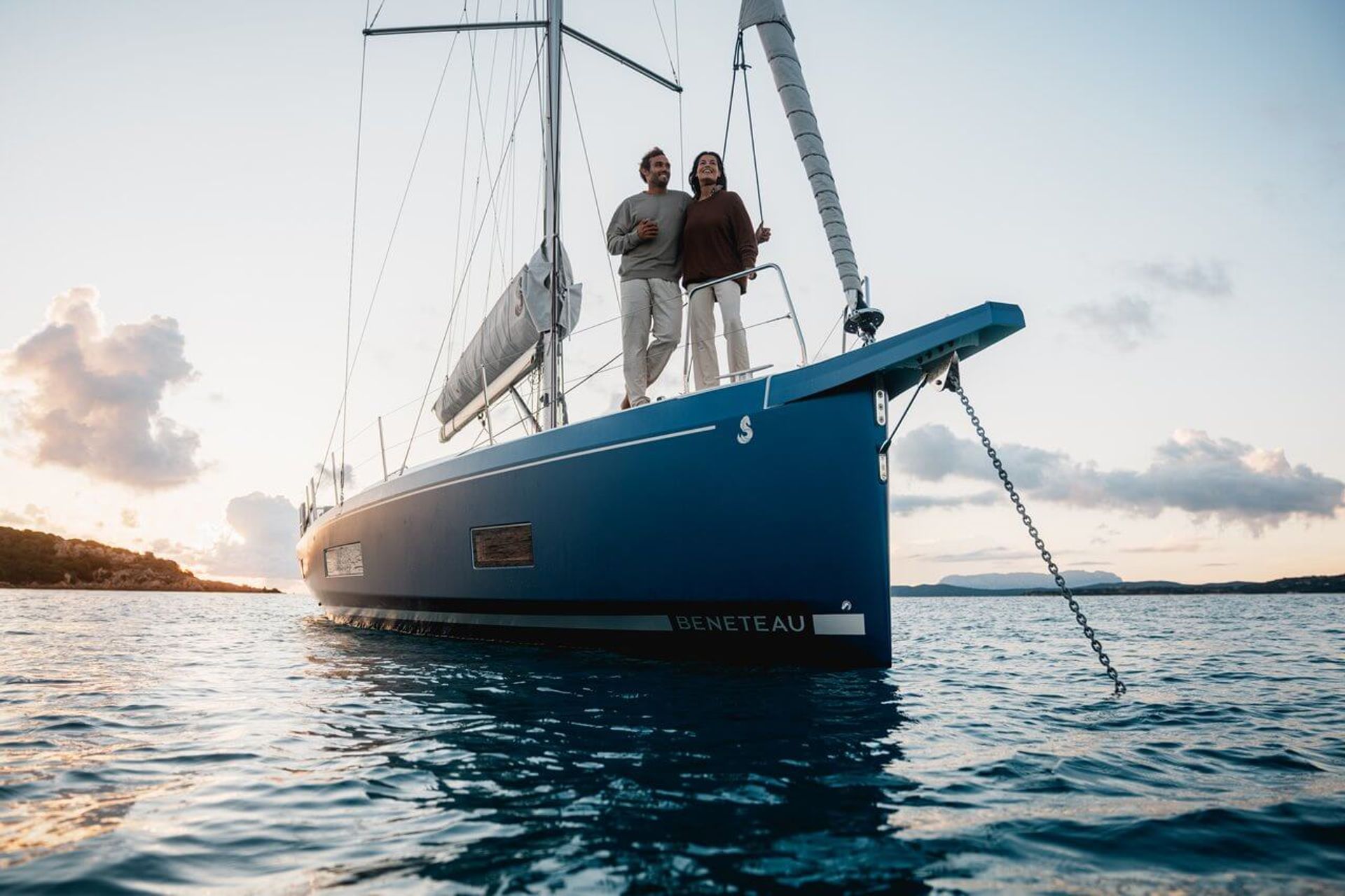Beneteau Oceanis 47 anchored, side view with guests relaxing on deck.
