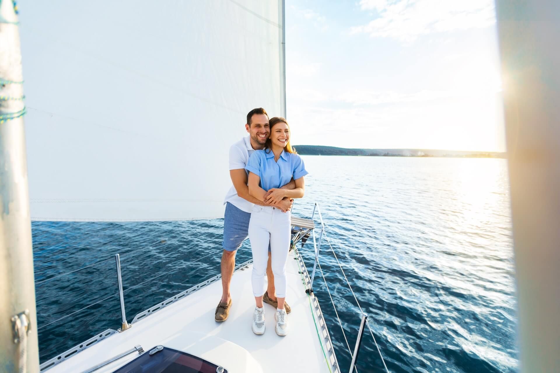 Couple Hugging On Yacht Spending Honeymoon Vacation Sailing Across The Sea Outdoors. Summer Romance. Empty Space.