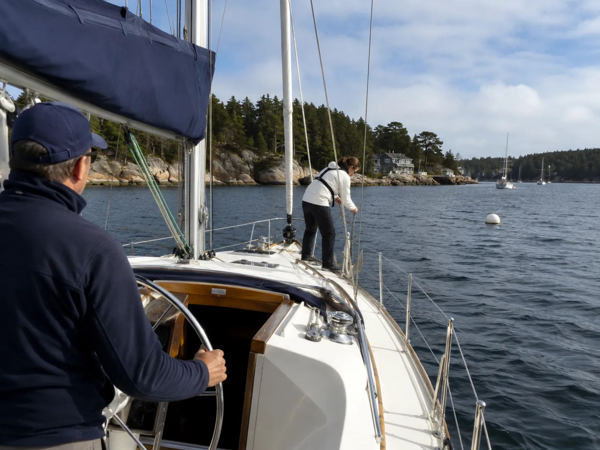 Crew member at the helm while approaching an anchorage