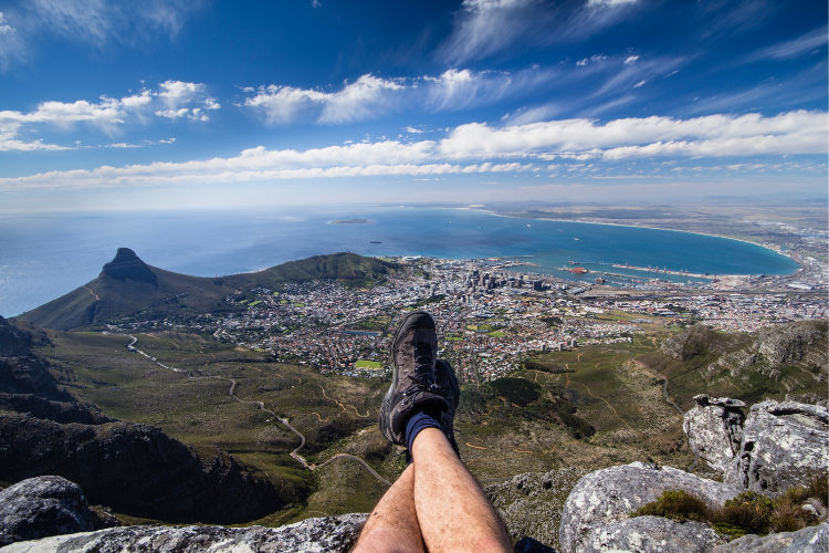 A Cape Town visitor relaxes to enjoy the view from the summit of Table Mountain.