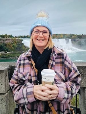 Image of Canada travel expert Angela Hill standing in front of Niagara Falls.