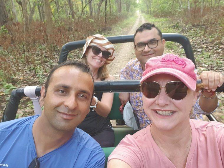Image of travel expert Lisa Thomas and her group smiling on a safari drive in Chitwan National Park, Nepal. 