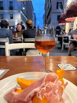 Prosciutto et melon image sur une assiette avec Spitz Aperol derrière, en Italie, qui a été prise par Sandy Colombo, expert en voyage en Italie.