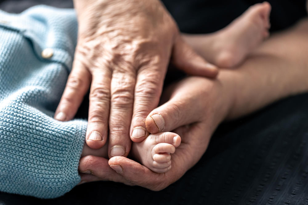 Feet of a newborn baby in the hands of a grandmother