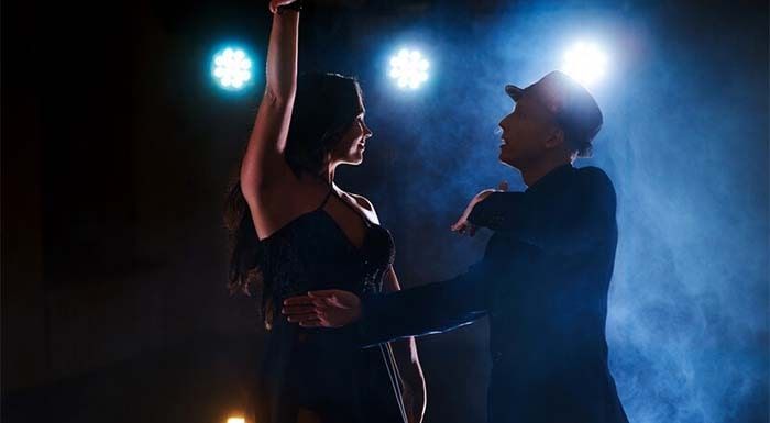 a man and woman dancing in the dark