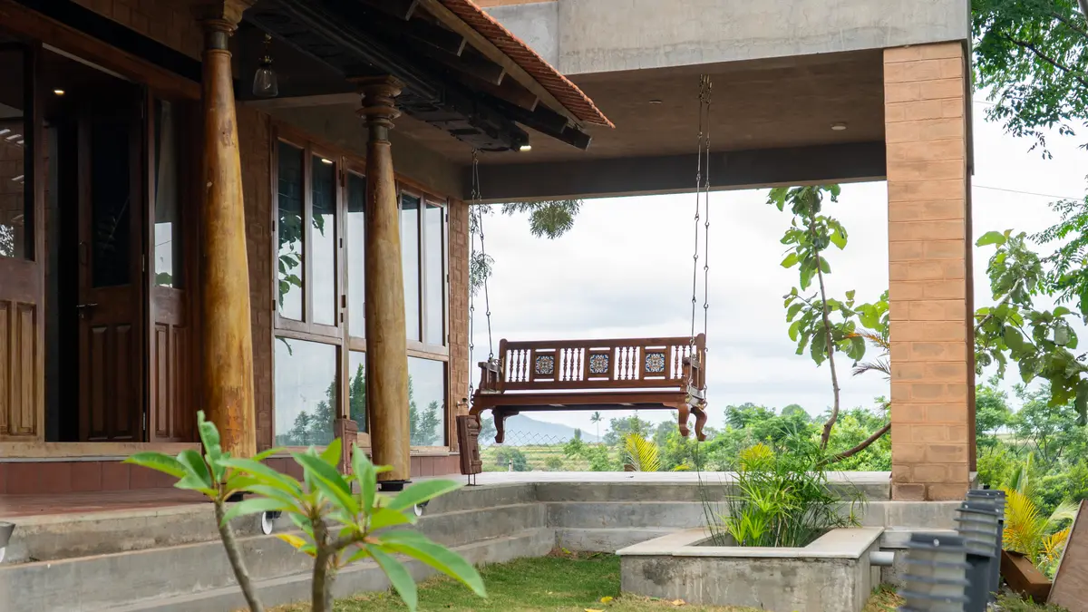 A traditional wooden swing adorns the outdoor space, offering a charming spot to relax and unwind.