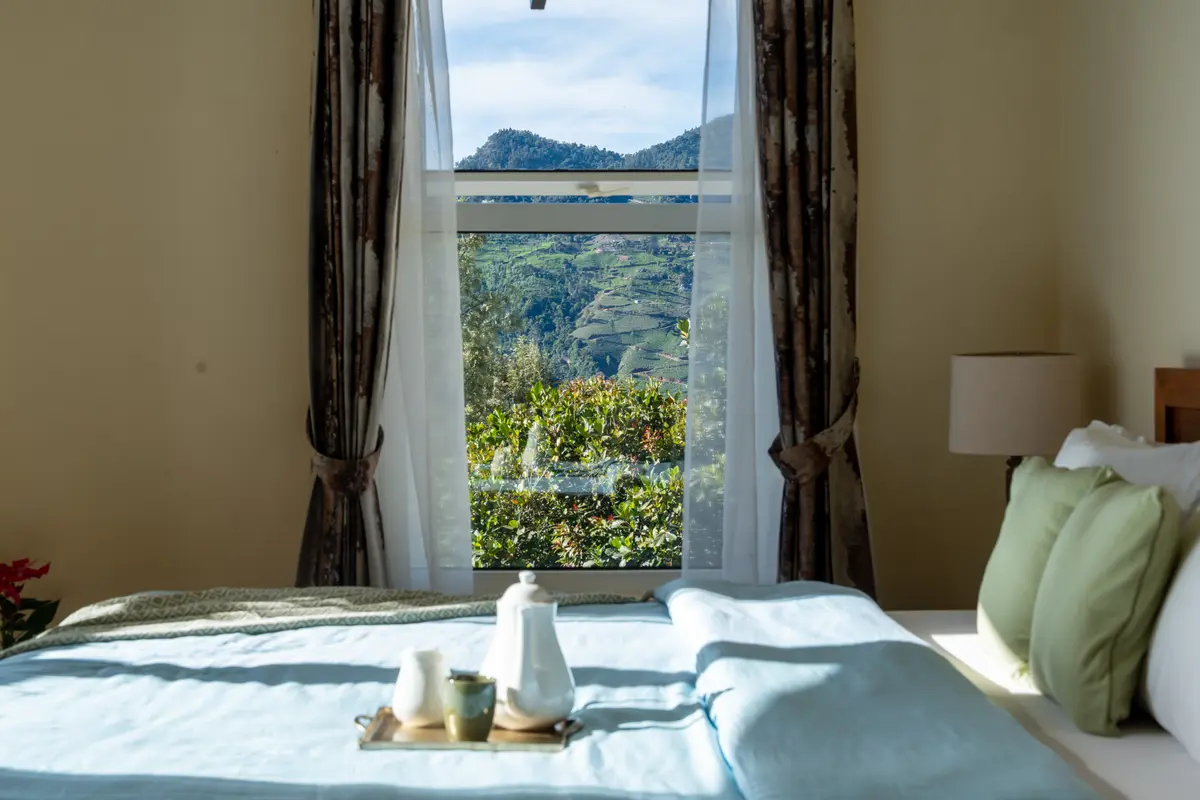 Mornings begin here, with sunlight on the bed and the hills framed perfectly beyond the window.