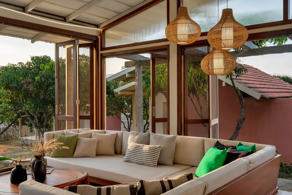 Sunlight, woven lamps, and wide-open views - where indoors gently dissolves into green.