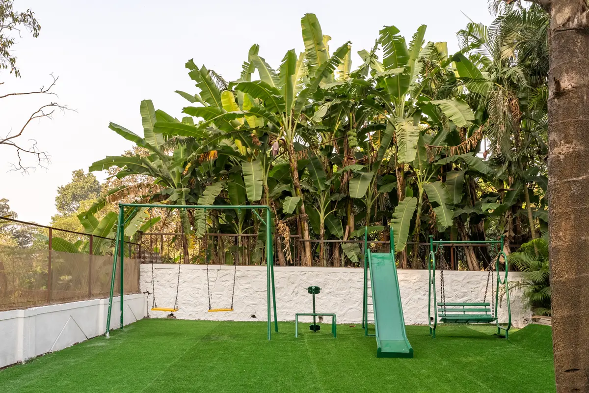Kids can enjoy the play area with the swings, slide, and lush greenery