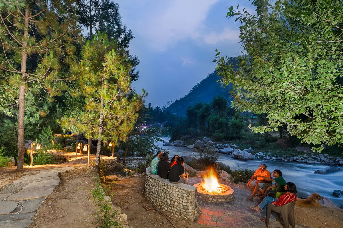 Spending time in the outdoor seating area by the river around the bonfire.