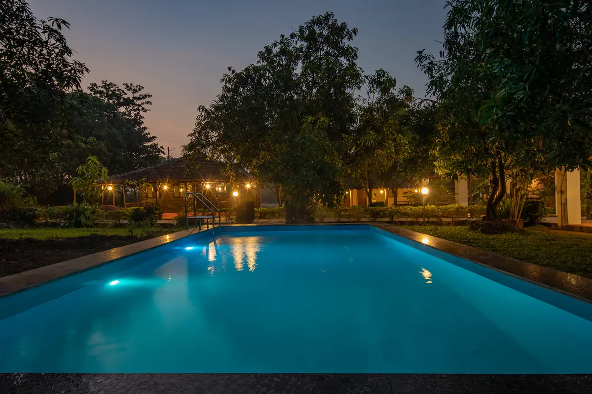 Enjoy a refreshing dip in the pool amidst lush greens.