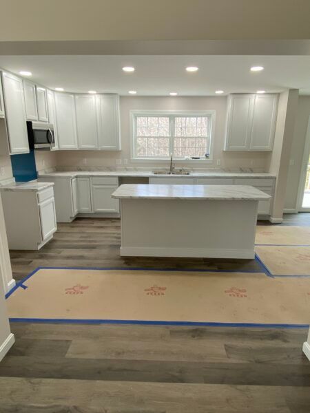 white kitchen with island in new custom modular ranch home project completed by Brookewood Builders, Manchester, ME 04351