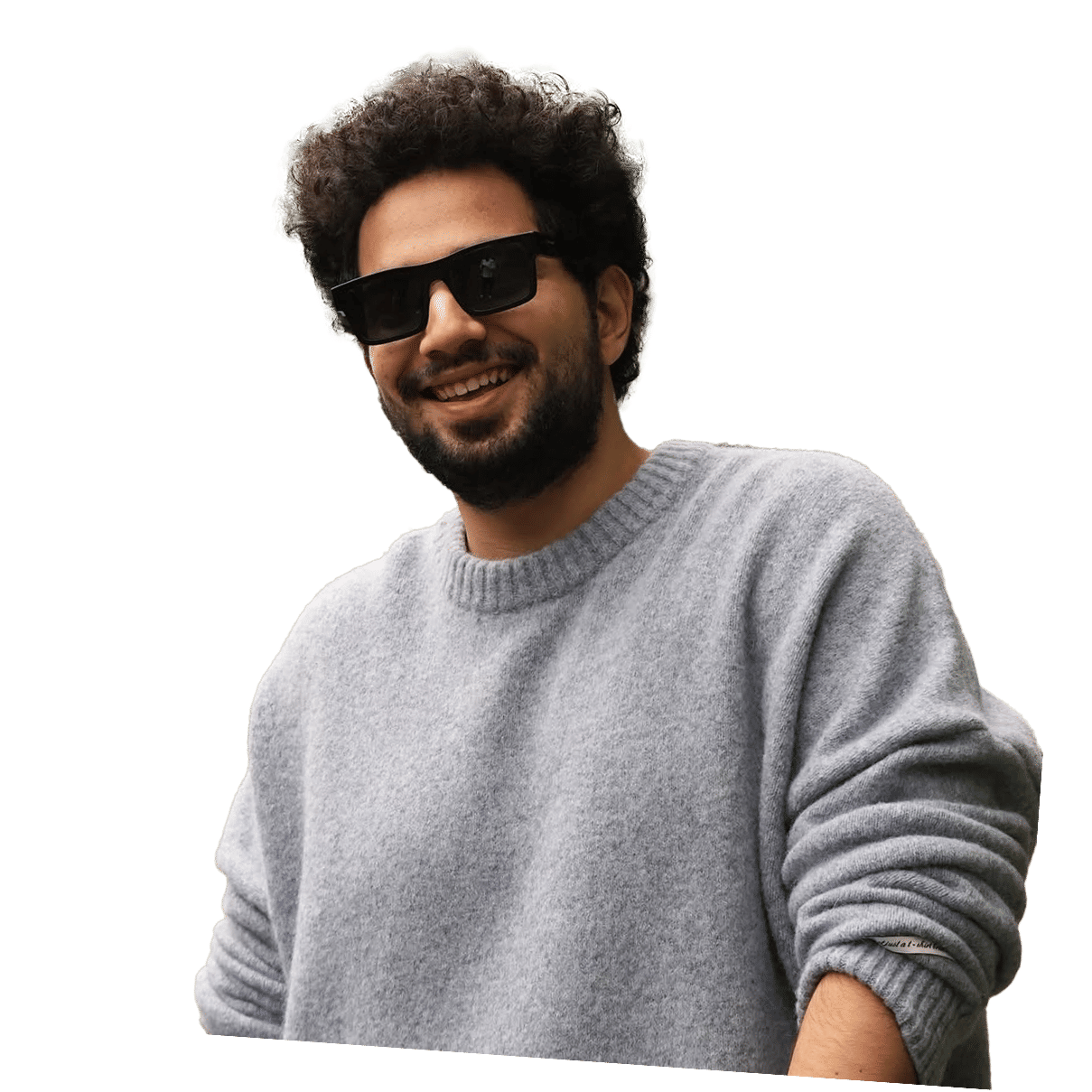 Samay Raina smiling in a gray sweater