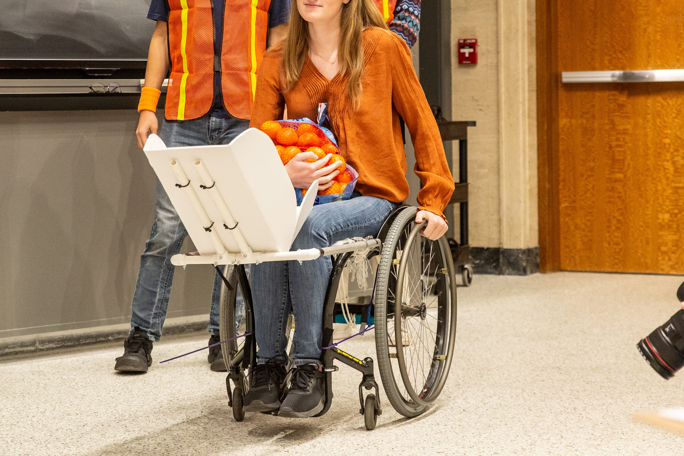 An attachment to give wheelchair-using parents independence to perform their daily tasks while safely bringing along their babies.
