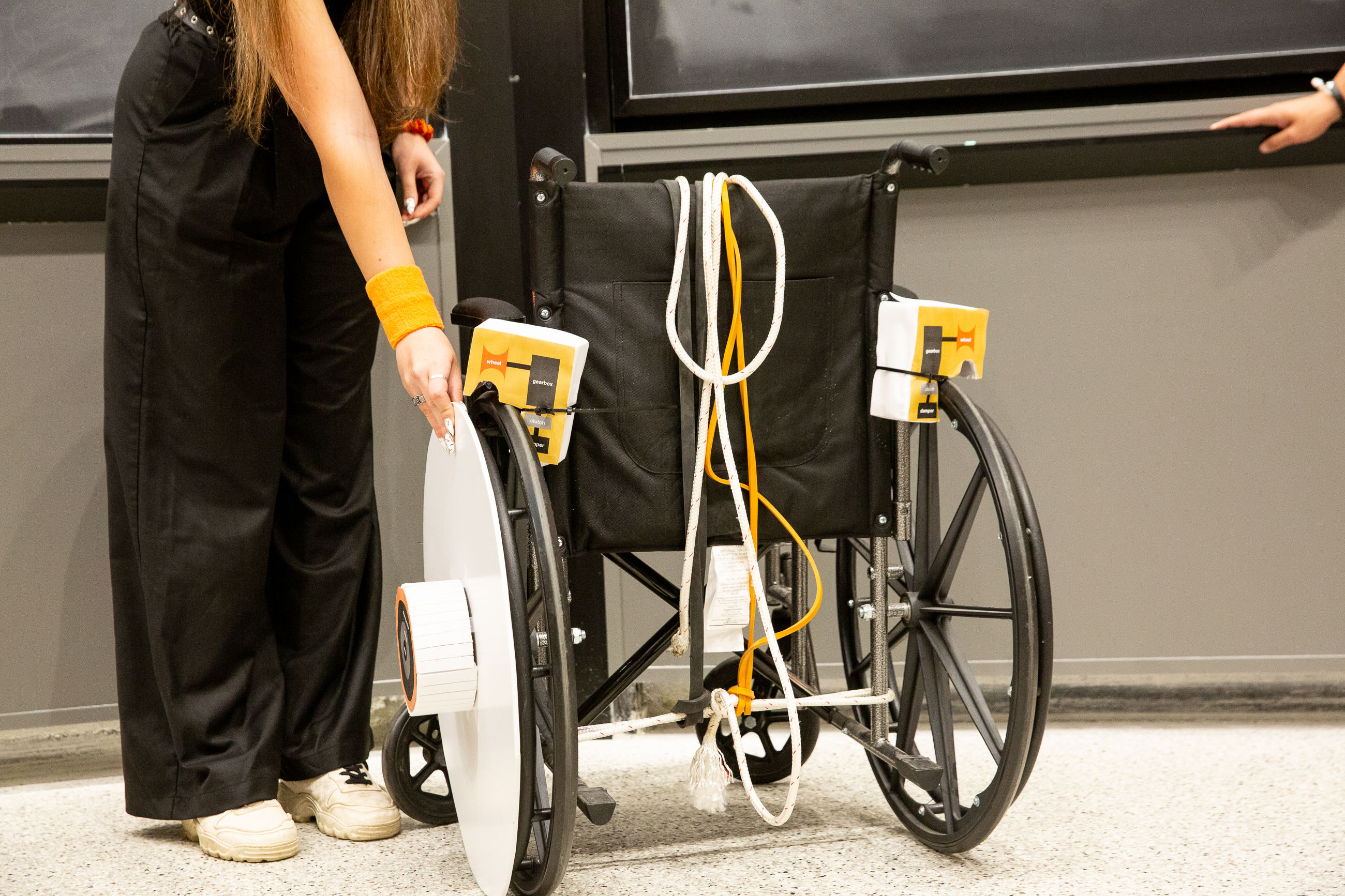 A device for wheelchairs to passively dampen high speeds, preventing uncontrollable descent down ramps and hills.