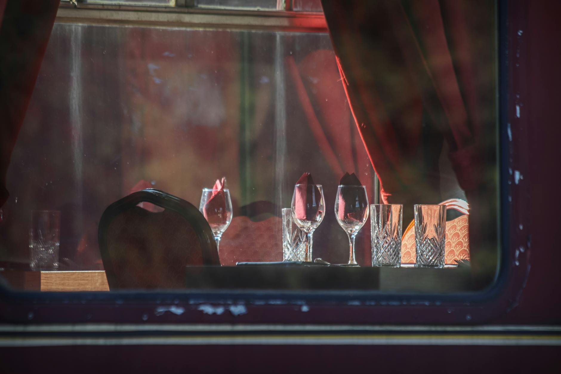 Traveler relaxing in plush cabin with scenic views, gourmet meal and travel essentials