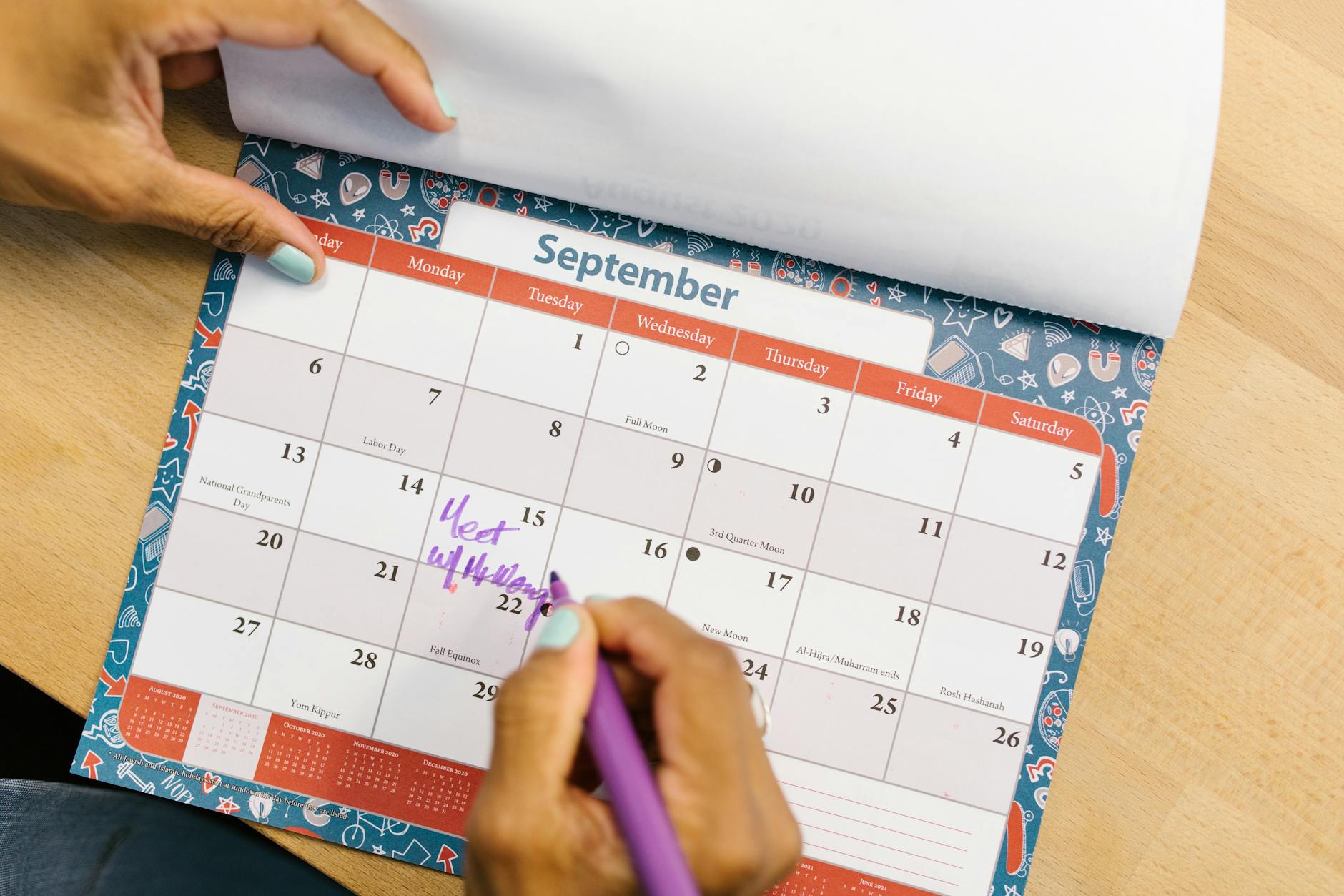 Traveler studying a detailed sports event calendar and travel map at a desk for trip planning