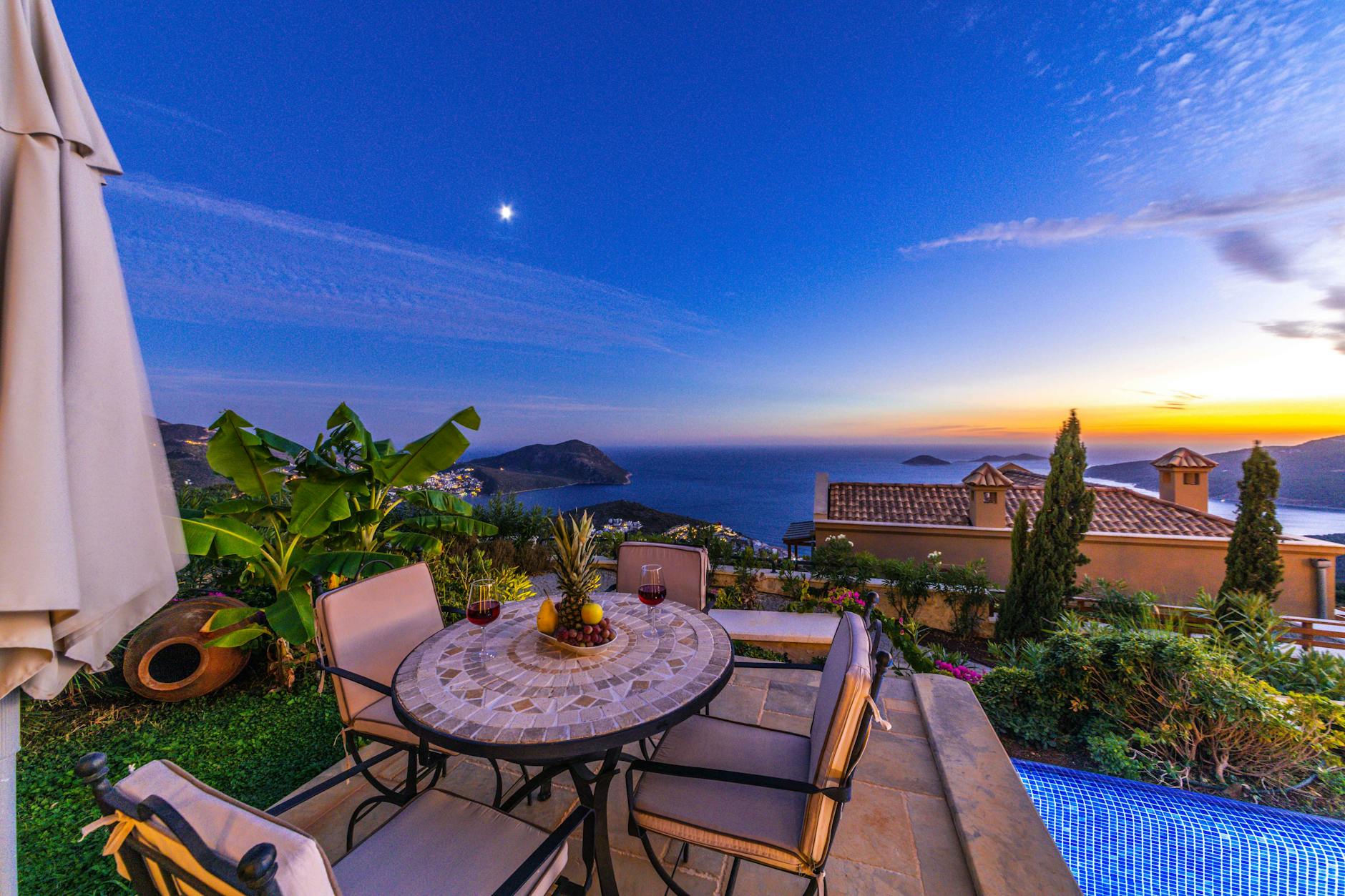 Sunset view of coastal town in Spain with beachfront yoga class and Mediterranean olive groves