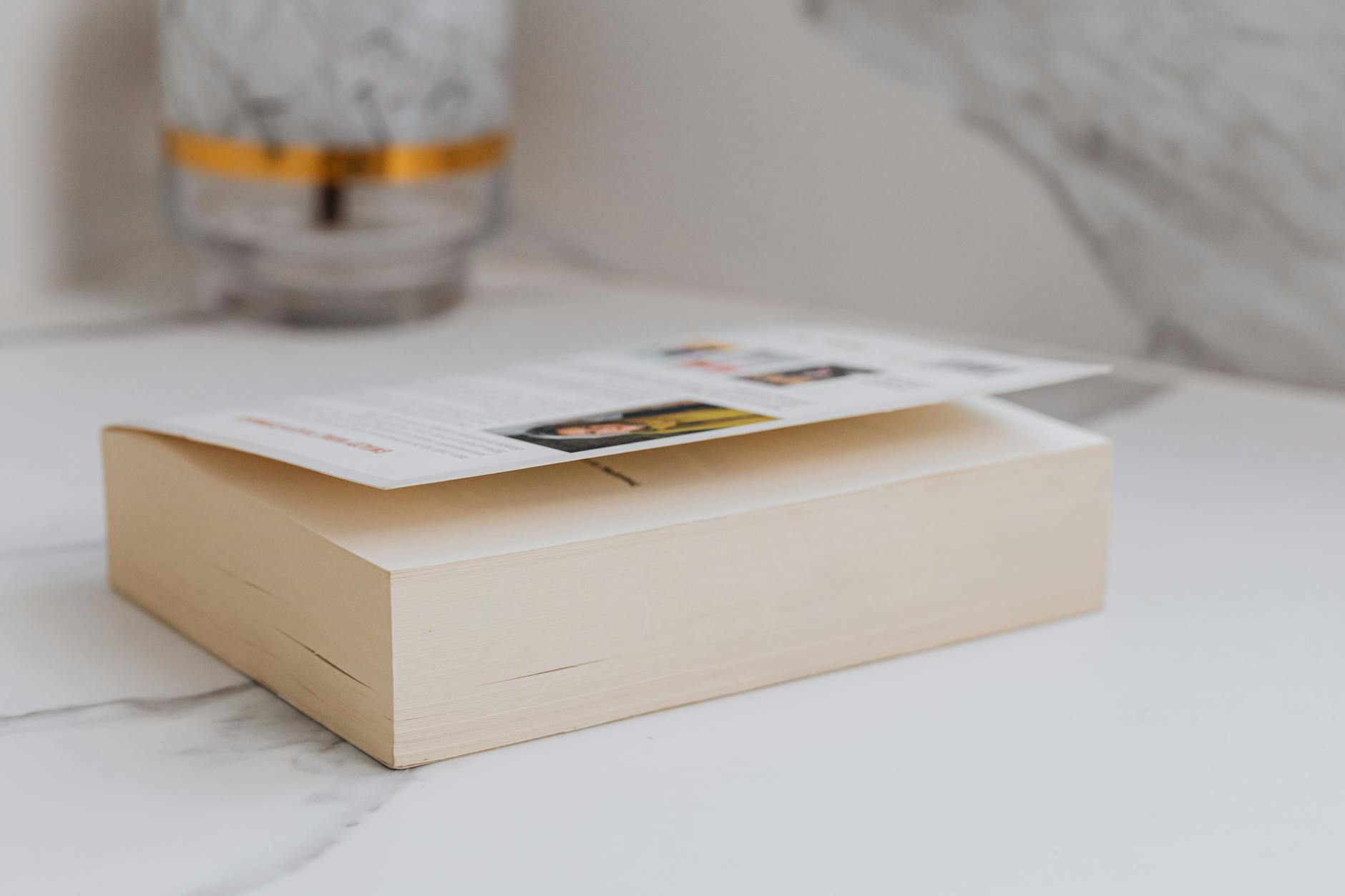 Stack of wellness guides and FAQ brochures on a wooden table with pen and reading glasses