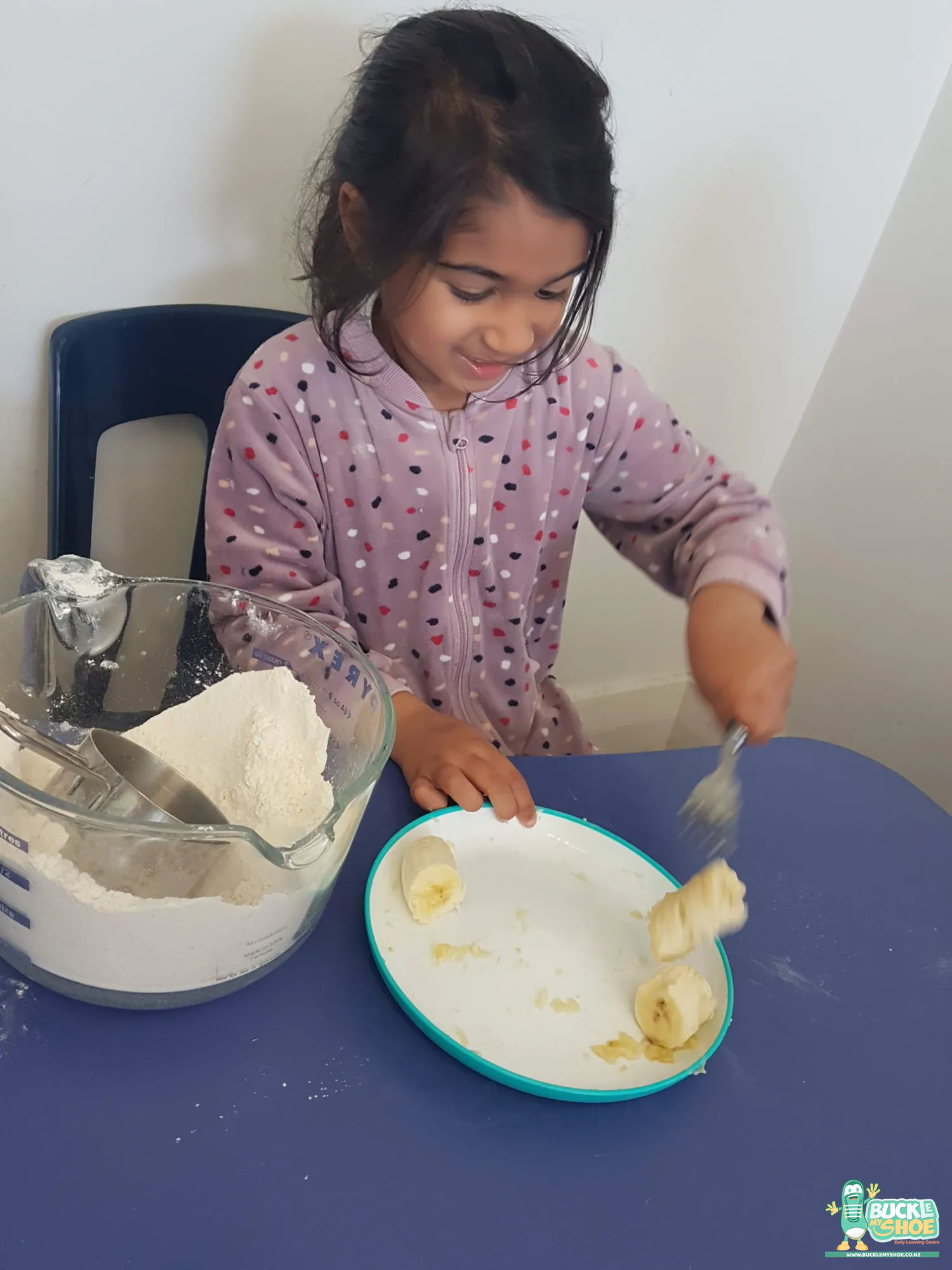 Buckle My Shoe Tauranga & Papamoa | Childcare, Preschool, Daycare | Three children laughing while sharing a bowl of freshly prepared fruit crumble.