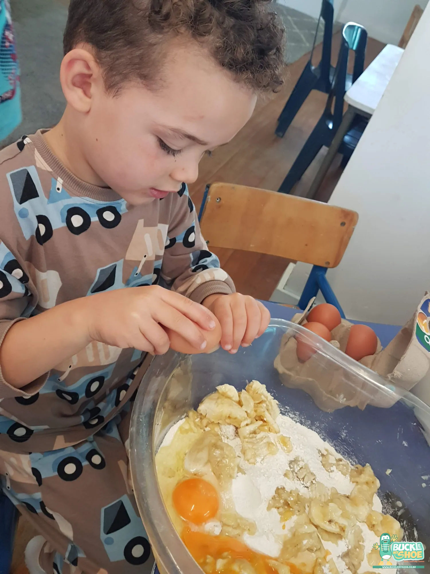 Buckle My Shoe Tauranga & Papamoa | Childcare, Preschool, Daycare | A child showing a finished tray of golden cookies with great excitement.