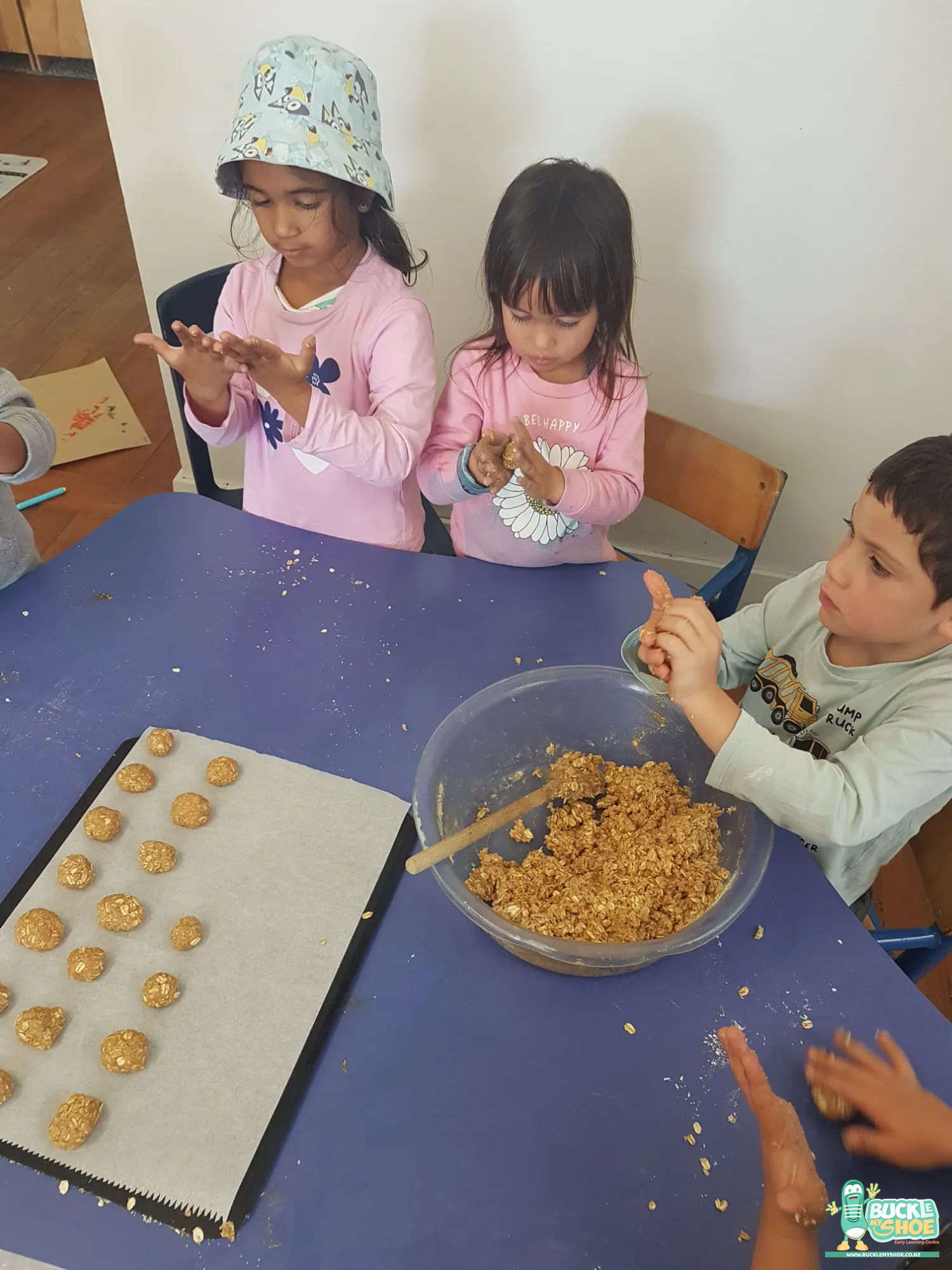 Buckle My Shoe Tauranga & Papamoa | Childcare, Preschool, Daycare | A close up of a child carefully decorating a small baked cake.