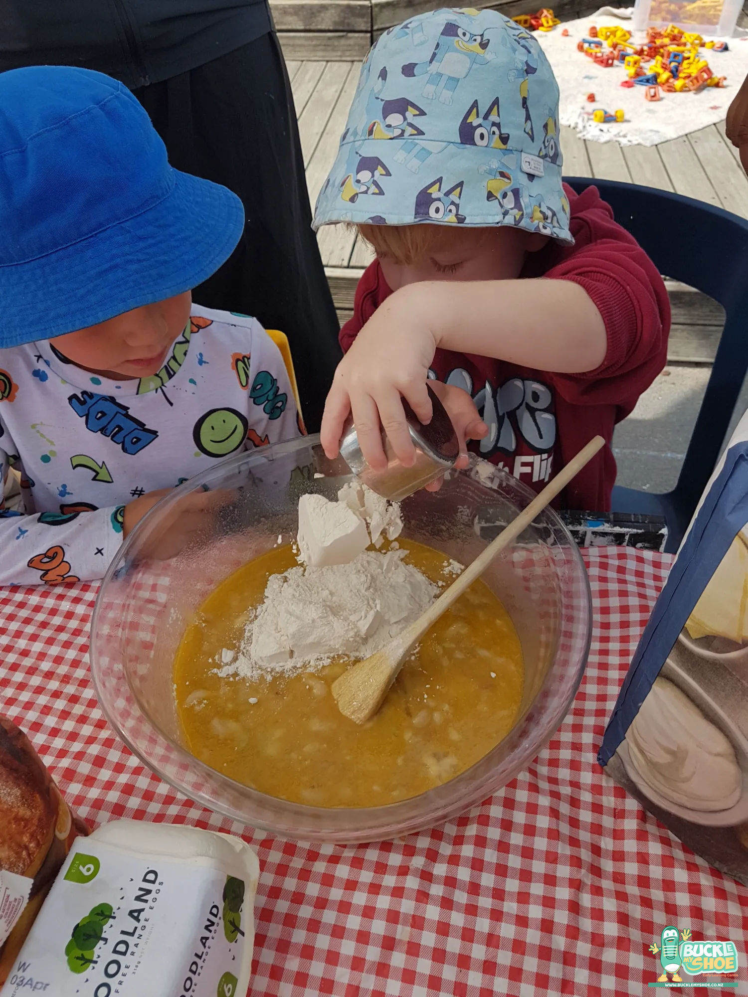 Buckle My Shoe Tauranga & Papamoa | Childcare, Preschool, Daycare | A close up of small hands carefully measuring ingredients into a bowl.