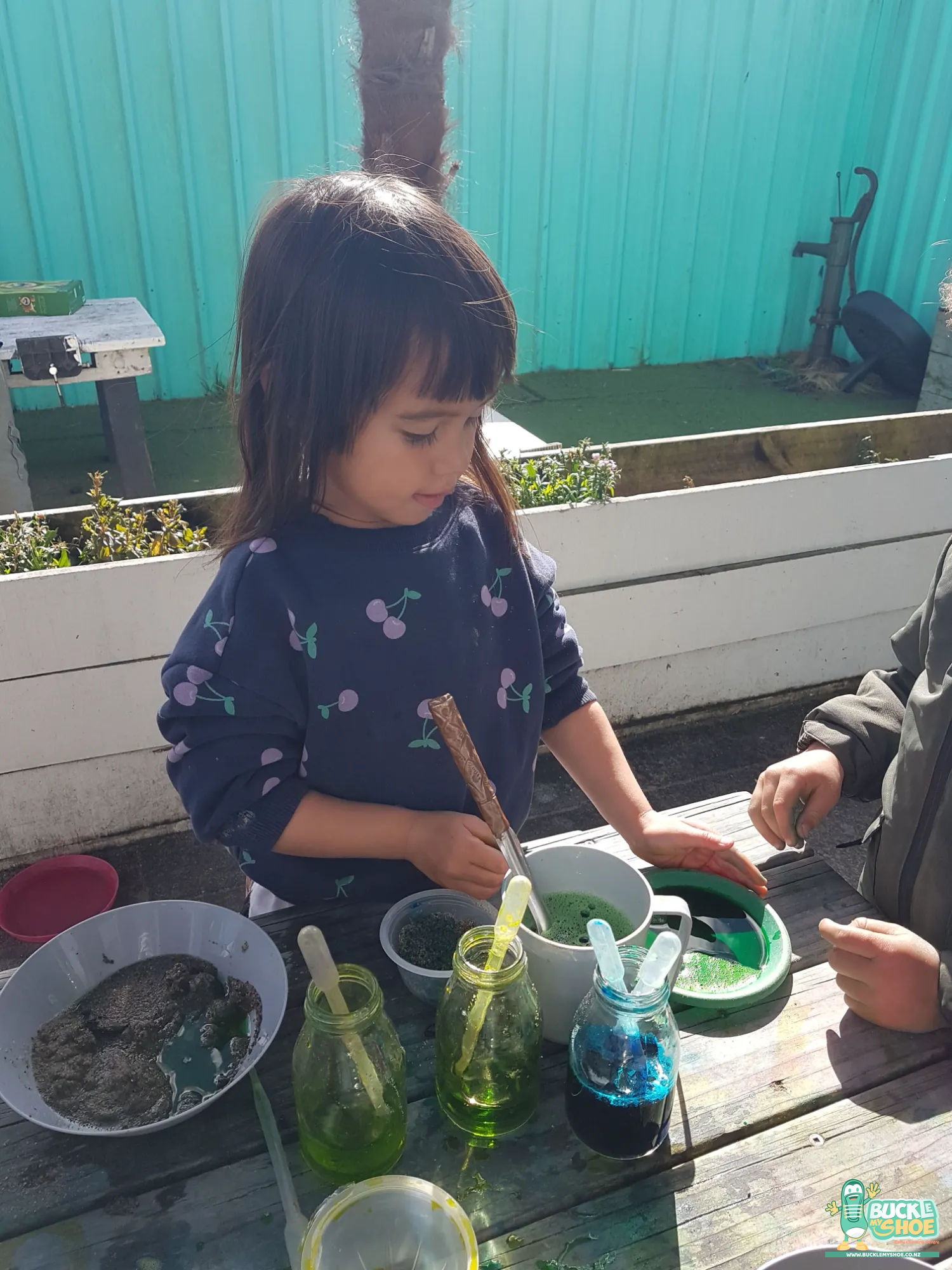 Buckle My Shoe Tauranga & Papamoa | Childcare, Preschool, Daycare | A child intently watching a colour change occur within their plastic container.