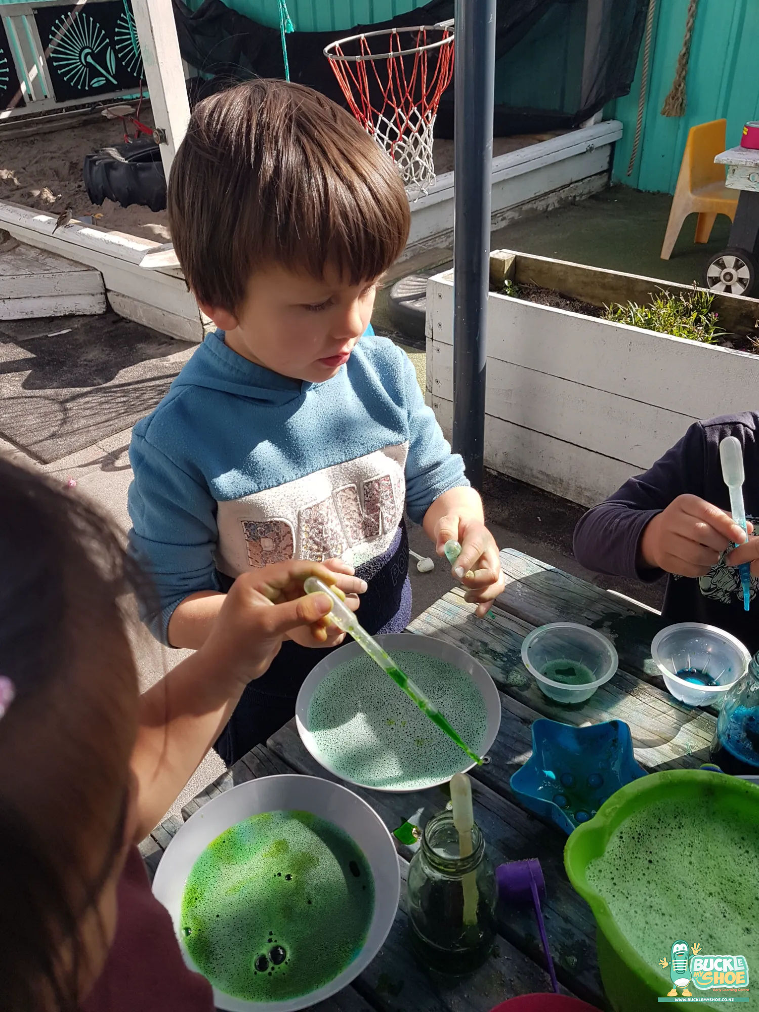 Buckle My Shoe Tauranga & Papamoa | Childcare, Preschool, Daycare | Group of tamariki working together around the table with focused, happy expressions.