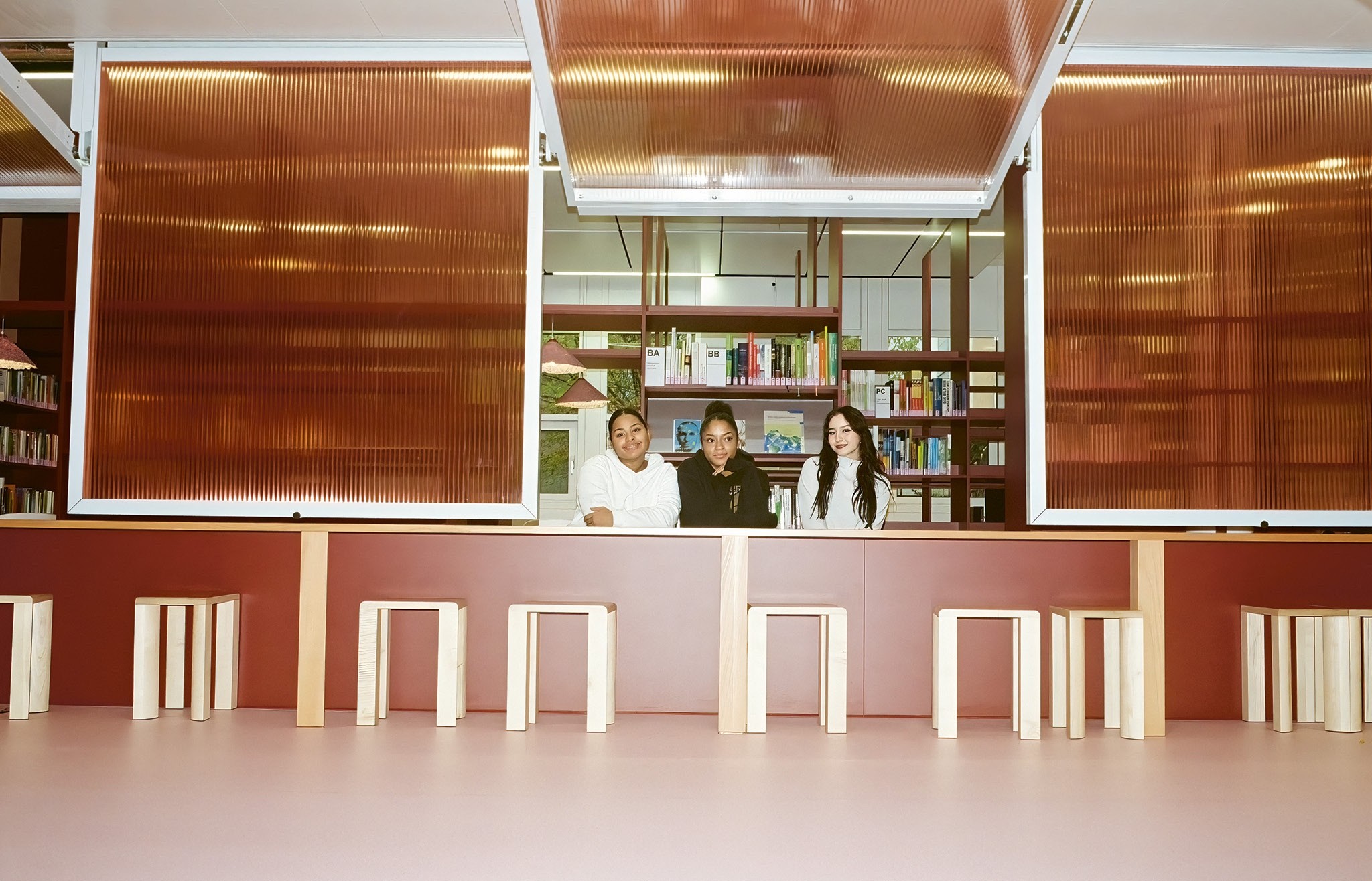 Warneri Peña, Simea Jungwirth und Cindy Nascimento, auszubildende Assistentinnen Gesundheit und Soziales, in der Bibliothek des von Kueng Caputo gestalteten Schulhauses.