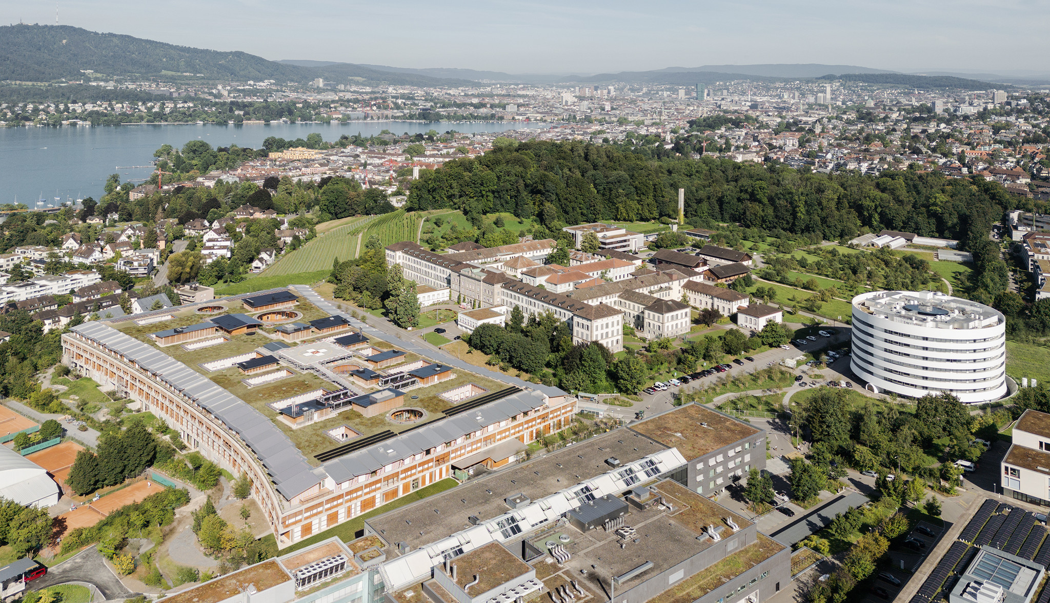 Der runde Forschungsbau und das teppichartige Akutspital schaffen Orientierung im ‹Gesundheitscluster Lengg› im Osten von Zürich.