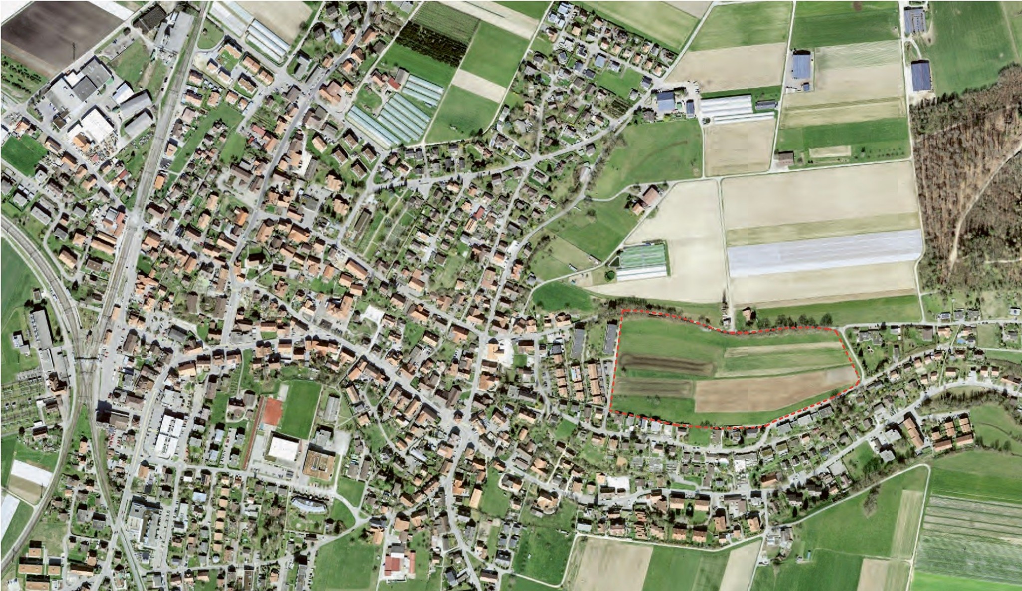 Die Gemeinde Kerzers und ihr saftiges Stück Bauland, der riesige Stockacker am östlichen Wohnfortsatz des Dorfs. Luftbild: www.geo.admin.ch; Bearbeitung: Hochparterre.