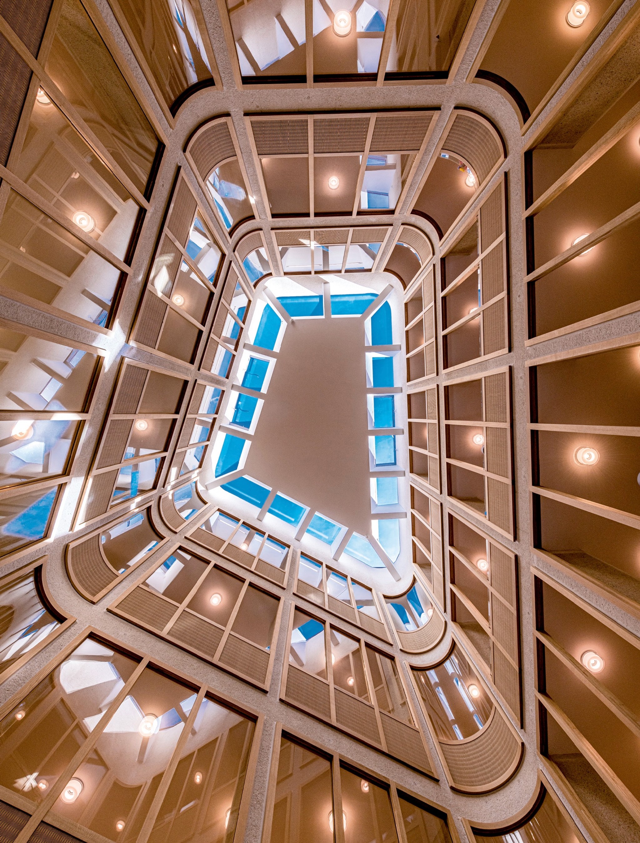 Blick von unten durch den Lichthof mit den Galerien: Die Verglasungen sorgen für eine helle Atmosphäre.