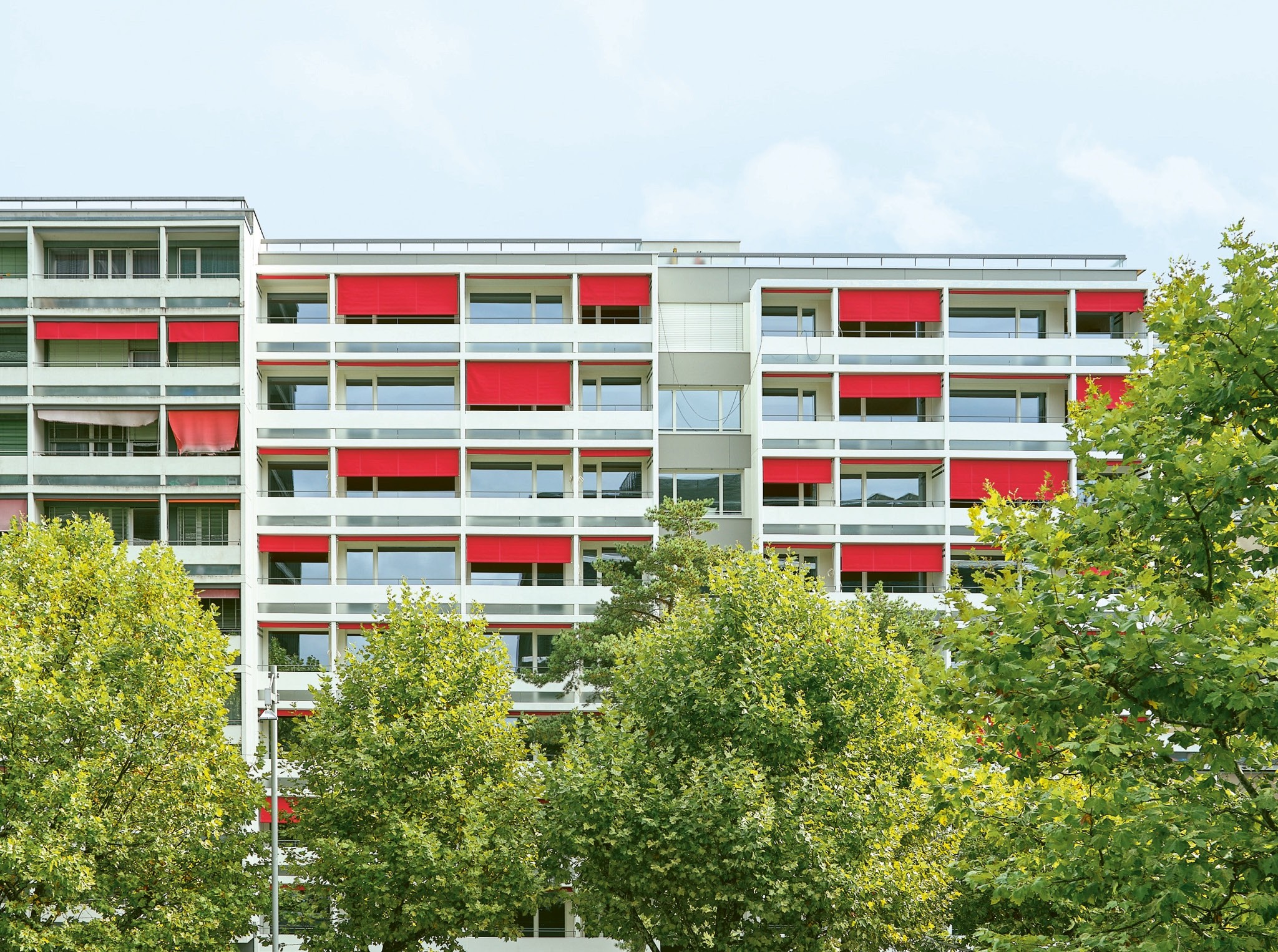 Auf den ersten Blick verrät nur das leuchtende Rot der Stoffstoren die Sanierung an der Giacomettistrasse 4.