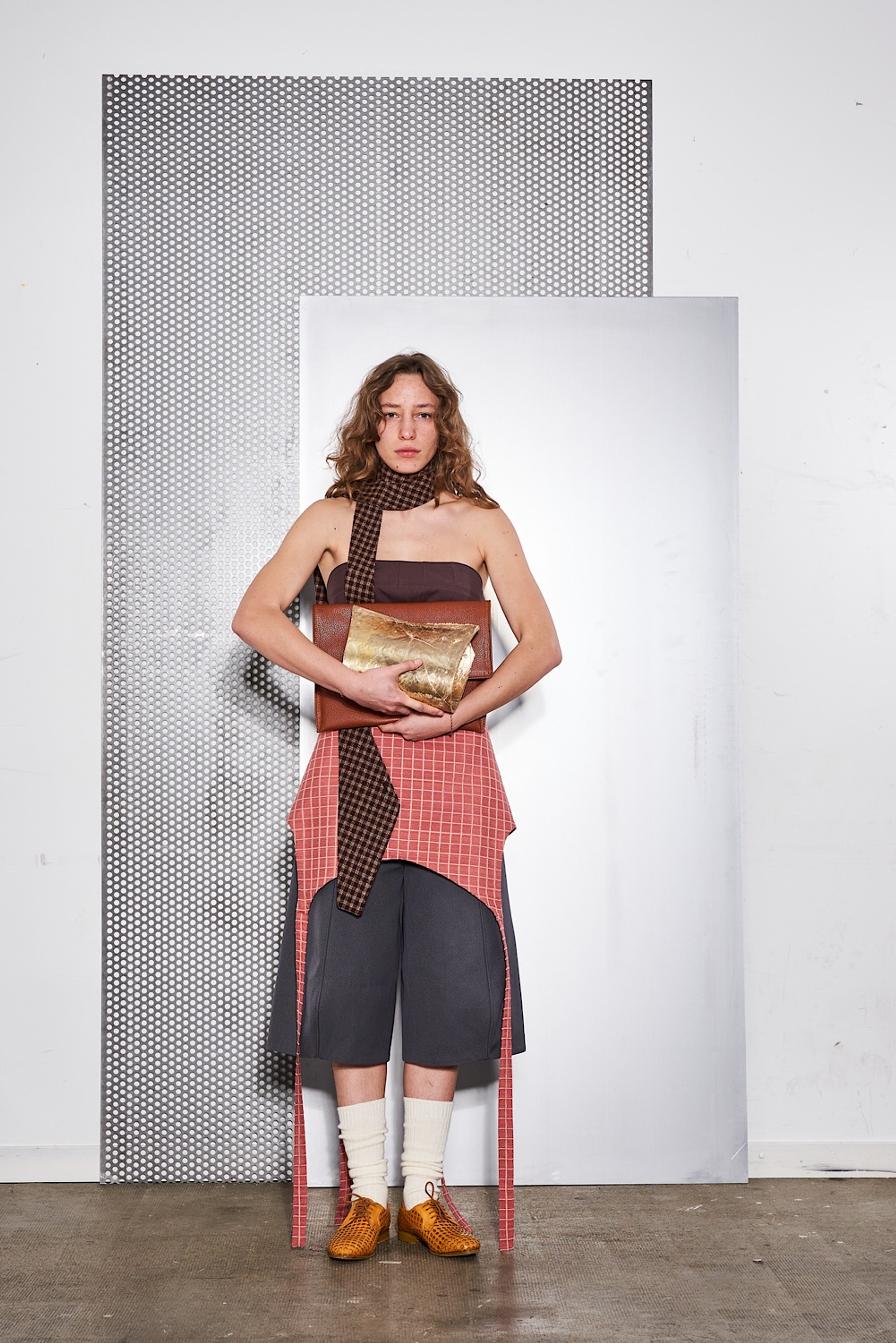 Look 3: Korsett-Top aus Baumwolle, Pointy Knee Shorts aus Denim, Rock aus Resttextil eines Polsterer-Atelier. Das Model, Uliana, hält eine Lederetui mit der Arbeitsdokumentation und ein Objekt aus Bronze von Luc Scapin. (@salvatoredefilippophotogragraphy)