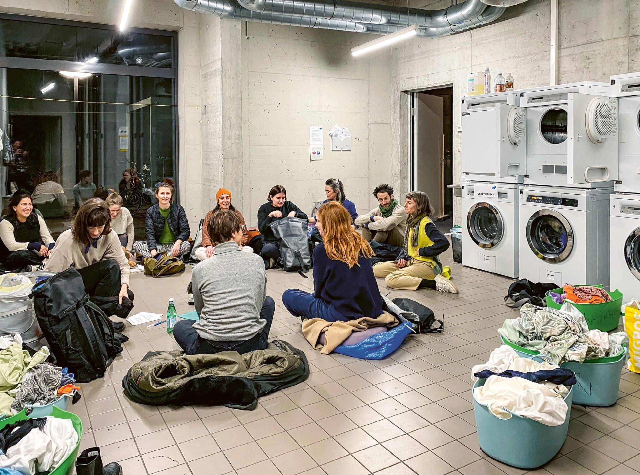 Sit-in in der Waschküche eines Hauses im Hunziker-Areal in Zürich Oerlikon: Als Sitzgelegenheit müssen die Jacken herhalten.