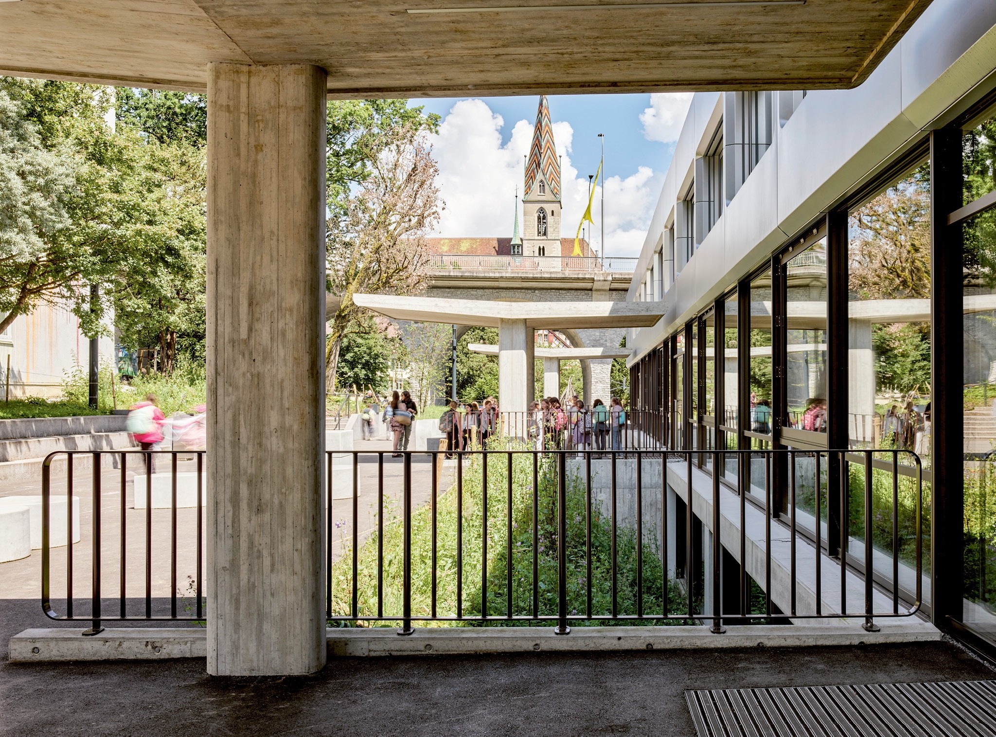 Leichte Vordächer aus Sichtbeton markieren die neue Zugangsseite der Pfaffechappe. Durch Verlegung der Eingänge hat sich die Orientierung im Schulhaus verbessert.