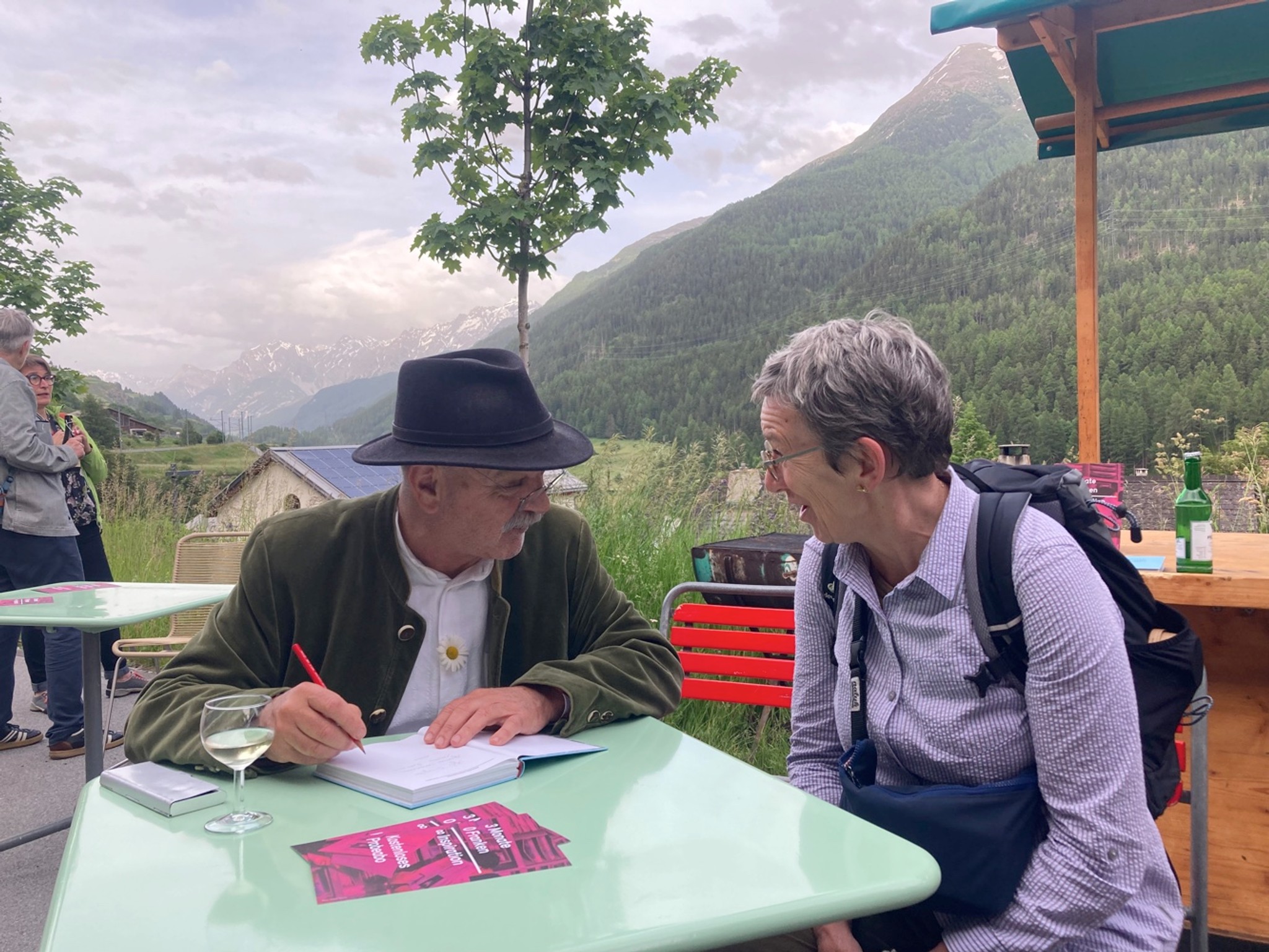 Köbi Gantenbein signiert sein neustes Werk «Bilderschatz und Sterngewölbe» an der Vernissage in Lavin.