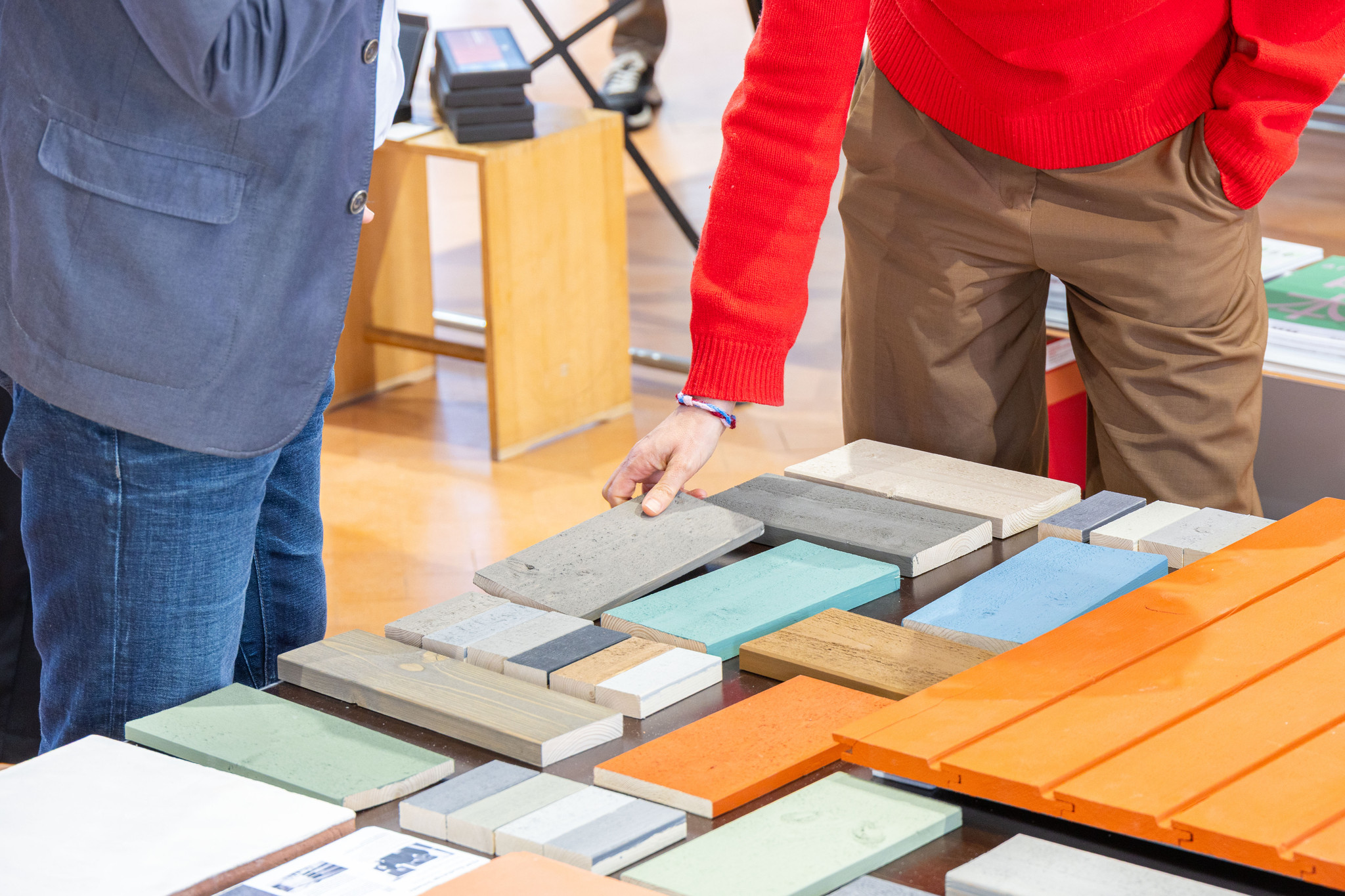 Das Publikum der Baumuster-Central beim Begutachten verschiedener Materialbeispiele der mineralischen Keim Farben.