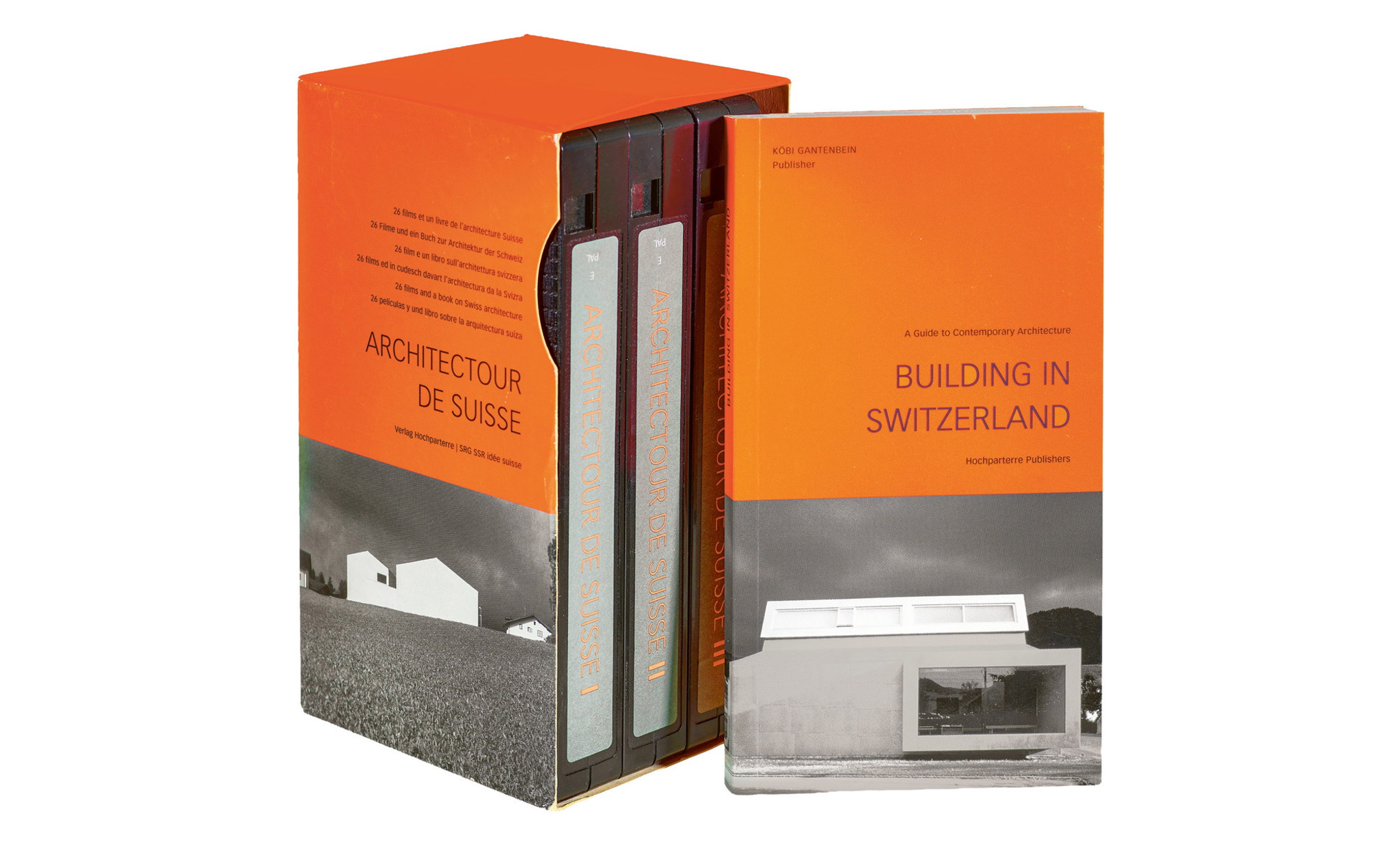 Schuber mit Taschenbuch und drei sogenannten VHS-Kassetten in der Modefarbe Orange