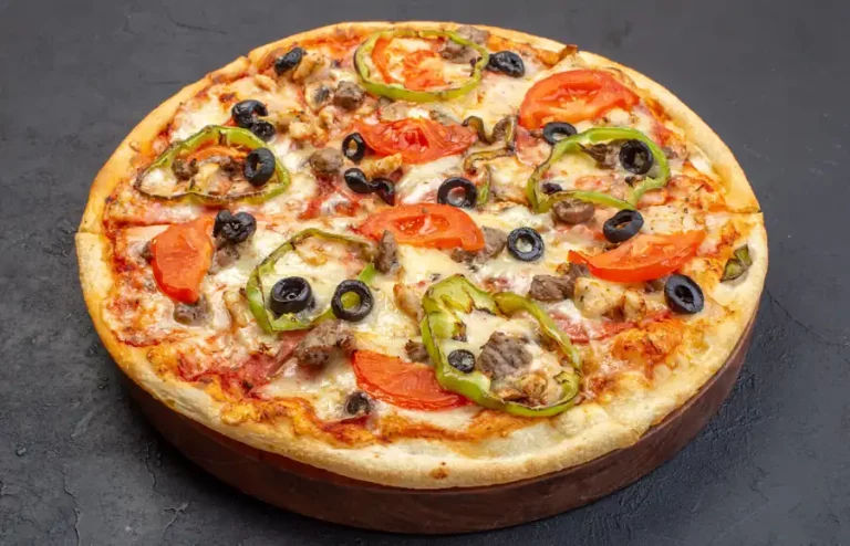 A delicious-looking pizza topped with meat, vegetables, and cheese.