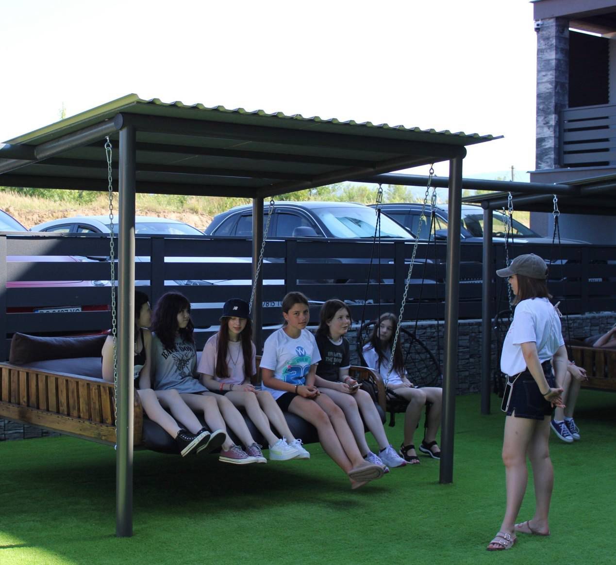 Camp participants talking in a sheltered outdoor seating area