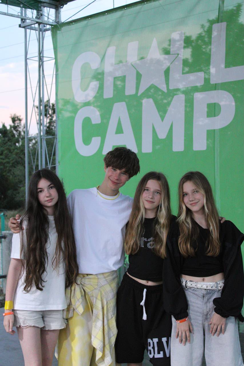 Camp participants together beside the camp sign