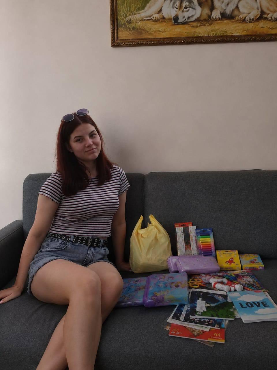 A student sitting beside notebooks and school supplies