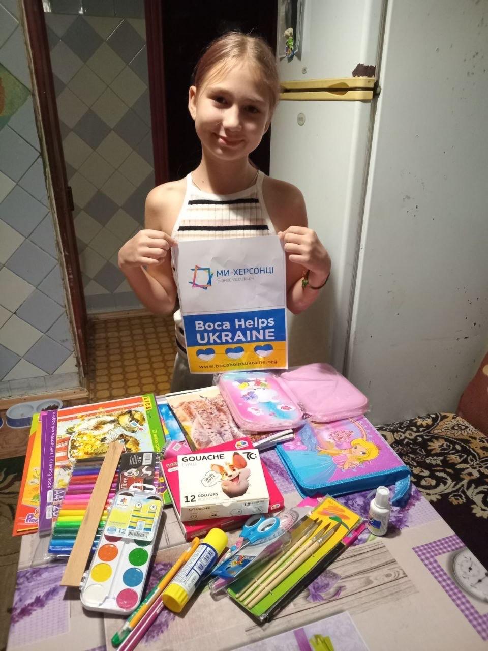 A student with notebooks, pens and art materials