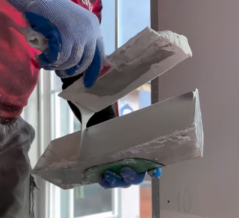 Using a taping knife and mud pan
