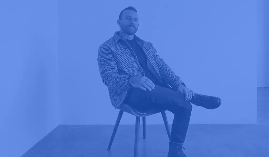 an image of Daniel form Rokitsite sitting on a chair with a medium blue coloured overlay